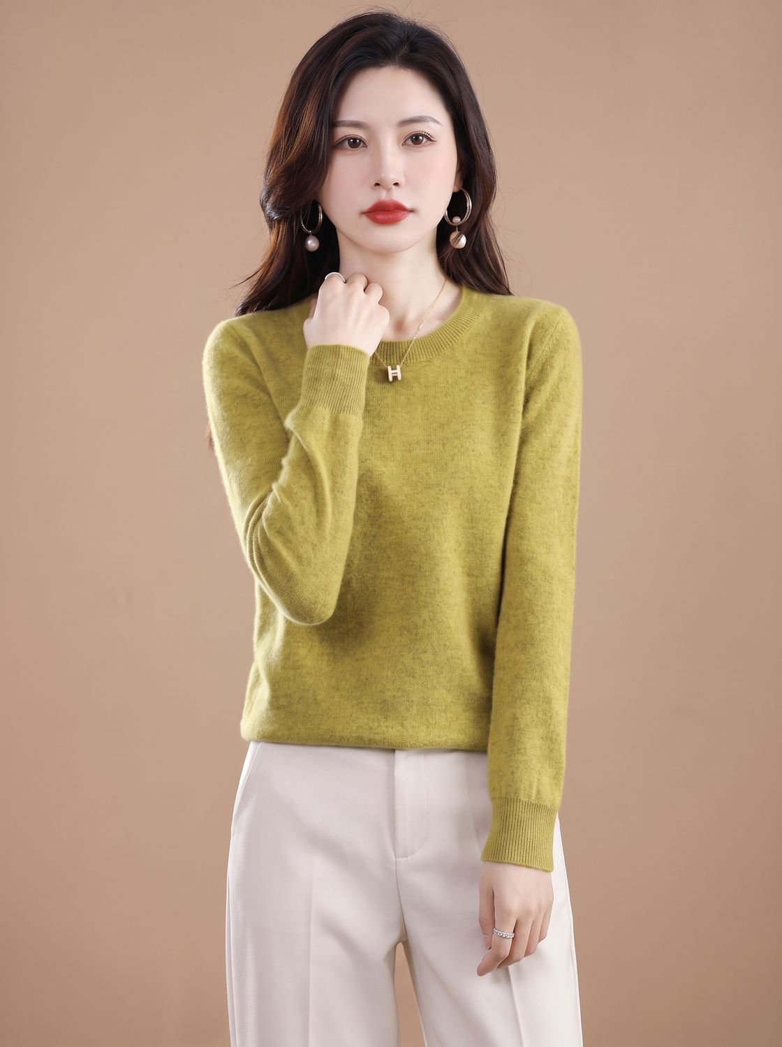 Women’s soft cashmere crew-neck sweater with long sleeves and breathable knit, worn casually in a cozy setting.