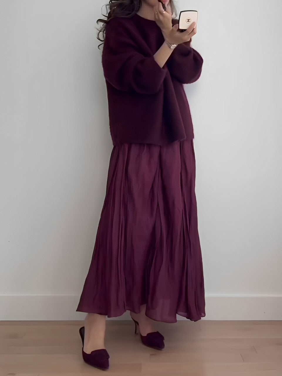 Women's two-piece skirt set by Homixa featuring a soft knit sweater and flowing pleated midi skirt, displayed on a model.
