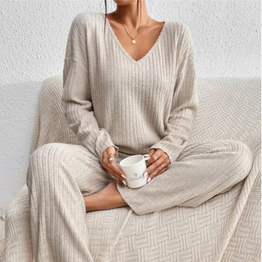 Women's V-neck knit two-piece set by Homixa featuring a long-sleeve top and elastic-waist pants, shown in a casual indoor setting.