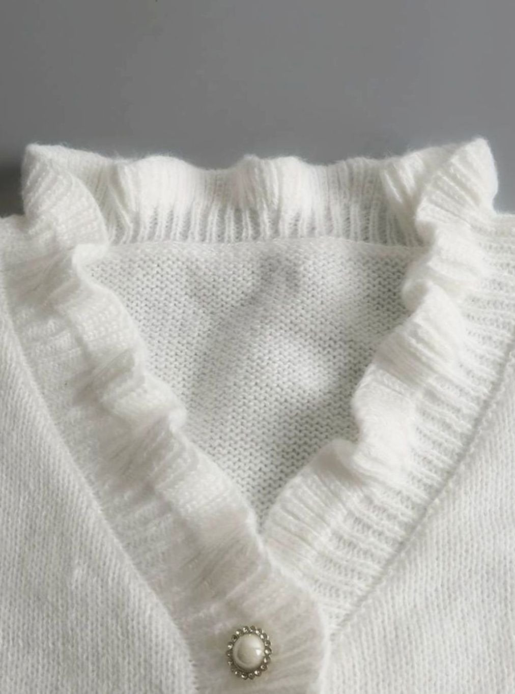 Homixa women's V-neck sweater with pearl buttons, ruffle trim at neck and cuffs, in a soft, cozy cardigan style.